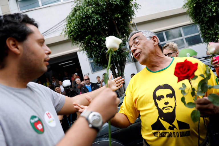 Apoiador de Haddad entrega flores a eleitor de Bolsonaro, em São Paulo
