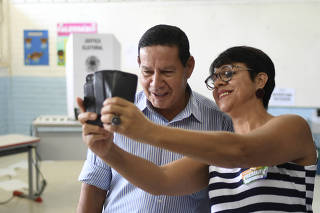O vice de Bolsonaro, General Mourão, faz selfie com eleitora ao votar