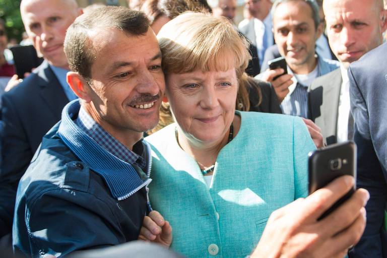 Refugiado faz selfie com a chanceler alemã, Angela Merkel, em Berlim 