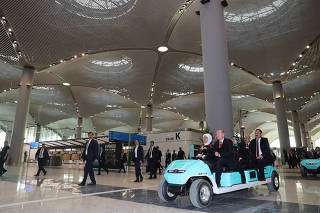 Turkish President Erdogan drives an airport golf cart during the official opening ceremony of Istanbul's new airport, in Istanbul
