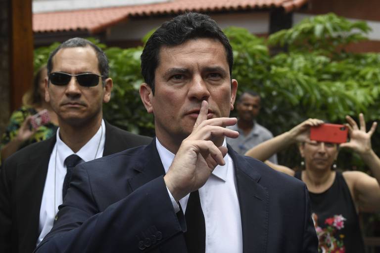 O juiz Sergio Moro pede silêncio ao falar com a imprensa no Rio de Janeiro, após aceitar o convite de Jair Bolsonaro para o Ministério da Justiça