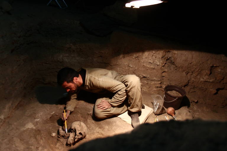 Pesquisador escavando esqueleto de paleoamericano achado na Lapa do Santo (MG)