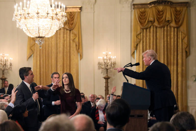 Momento em que uma auxiliar da Casa Branca tenta pegar o microfone de Jim Acosta enquanto ele debate com Donald Trump 