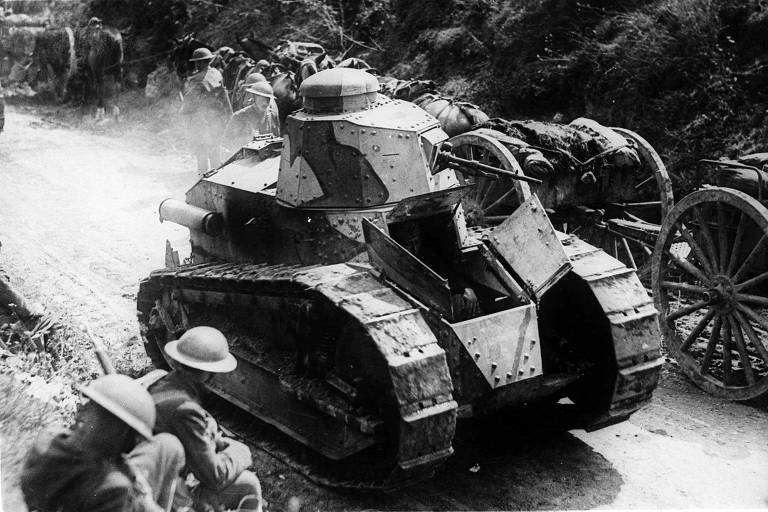 Dois soldados passam ao lado de um tanque a caminho para dar apoio às tropas da França em Juvigny