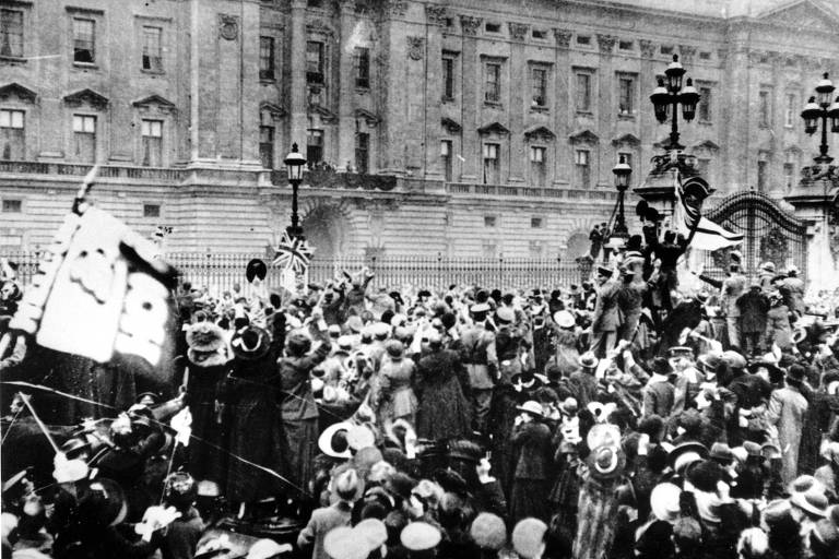 Pessoas celebram o armistício que deu fim à Primeira Guerra Mundial em frente ao Palácio de Buckingham, em Londres