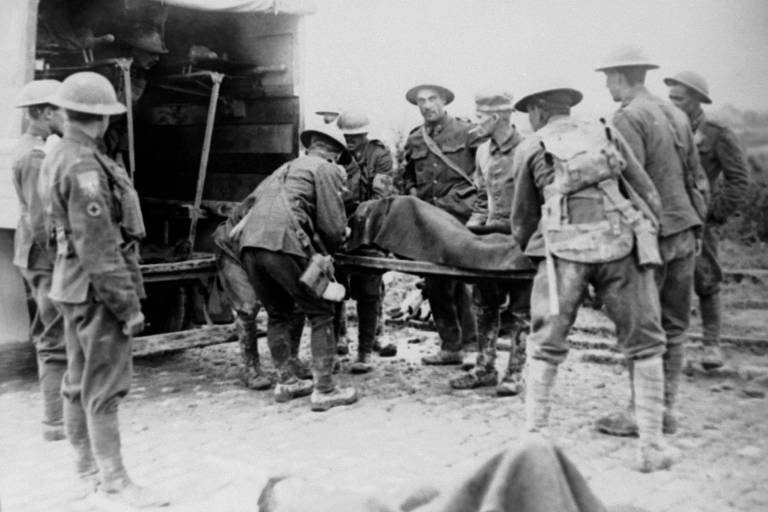 Feridos durante os combates são transportados para ambulâncias durante o avanço em Lens, na França