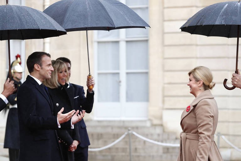 O presidente francês Emmanuel Macron e sua esposa, a primeira-dama Brigitte, recebem a presidente da Croácia, Kolinda Grabar-Kitarovic, no Palácio do Eliseu. A imagem dos dois líderes de Estado sob forte chuva na entrega dos prêmios da Copa do Mundo marcou o mundial 
