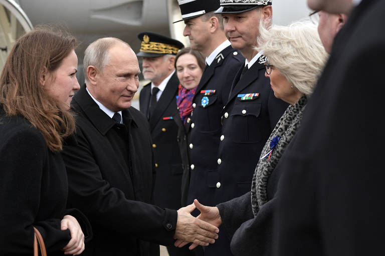 O presidente russo Vladimir Putin cumprimenta oficiais franceses em Paris; ele é um dos convidados das celebrações do centenário do fim da Primeira Guerra Mundial, na qual a Rússia lutou ao lado da França