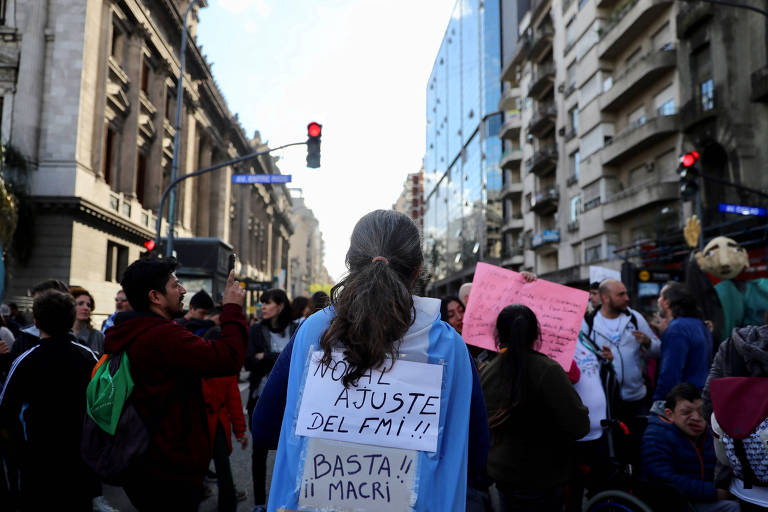 Manifestante usa placa com frase contra o acordo do governo com o FMI em ato em Buenos Aires