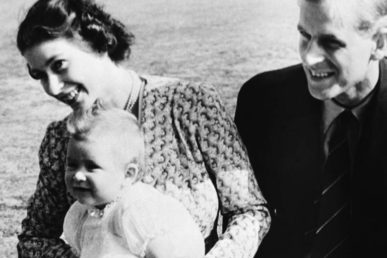 18 de julho de 1949: a então princesa Elizabeth com seu marido, Philip, quando George tinha oito meses de idade, na residência de verão da família em Ascot, na Inglaterra 