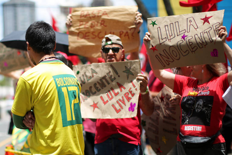 Manifestantes pró-Lula nos arredores da Justiça Federal do Paraná levantam cartazes em apoio ao ex-presidente