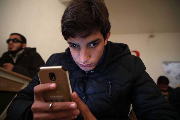 Estudante cego aprende a usar app para smartphone na cidade de Anjara, na Síria 