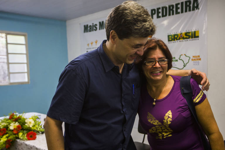 José de Filippi Junior, então secretário de Saúde de Pedreira, ao lado da médica cubana Tania Sosa em seu primeiro dia na cidade, em Santo Antônio de Posse (SP). Os médicos já instalados nos municípios onde atuariam por três anos, passaram o dia dando entrevistas, visitando postos, acertando detalhes burocráticos e recebendo presentes