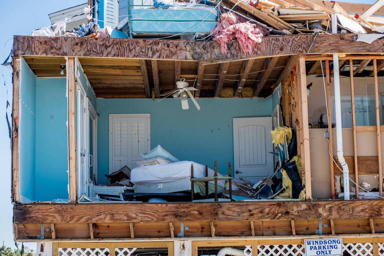 Casa danificada após passagem do furacão Michael; dentro do quarto, exposto ao ar livre, é possível ver uma cama