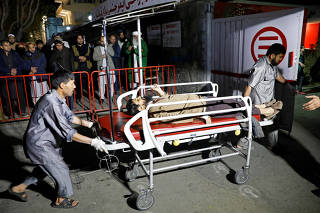 Hospital workers carry an injured person to a hospital after a suicide attack in Kabul