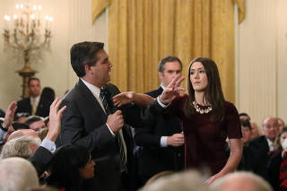FILE PHOTO: White House intern reaches for microphone held by CNN's Acosta as he questions U.S. President Trump during news conference in Washington