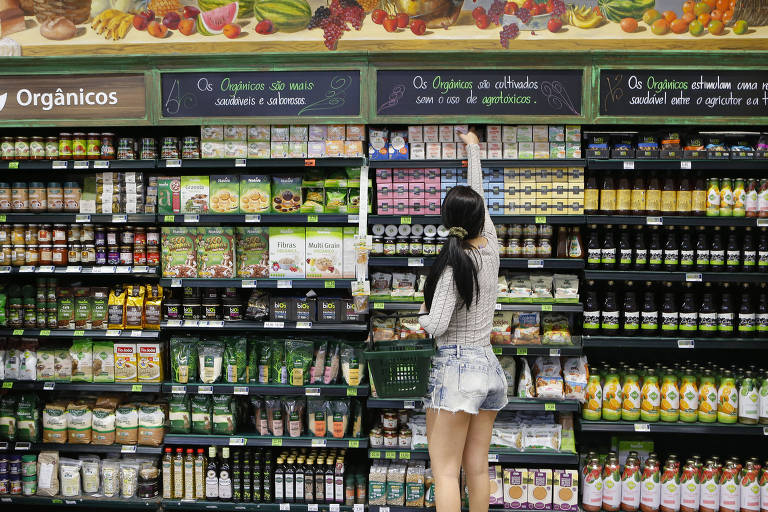 Consumidora avalia prateleira de supermercado
