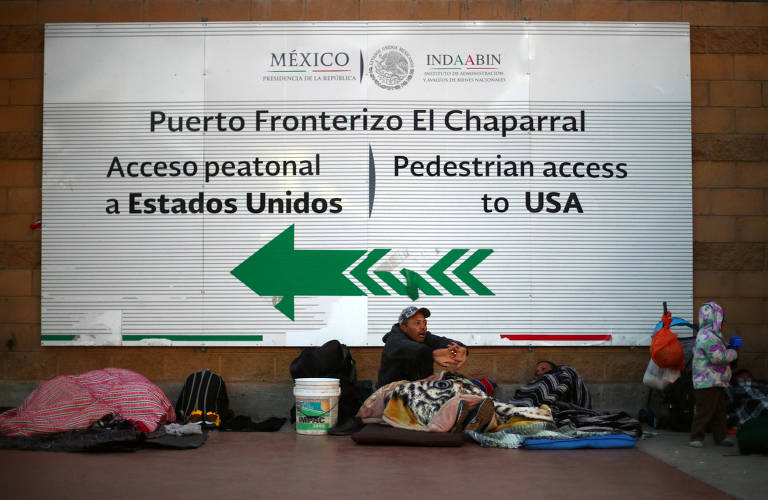 Grupo de migrantes centro-americanos descansa perto da passagem de fronteira chamada de El Chaparral