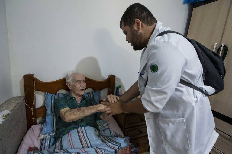 O médico Cássio Francisco Gonçalves durante visita ao aposentado Mario Pedra da Silva, 81 anos, que sofre de hipertensão. diabetes e anemia profunda e tem dificuldades de se locomover. As visitas fazem parte do programa Saúde da Família, na zona sul da cidade, próximo à UBS Santa Catarina, no bairro do Jabaquara