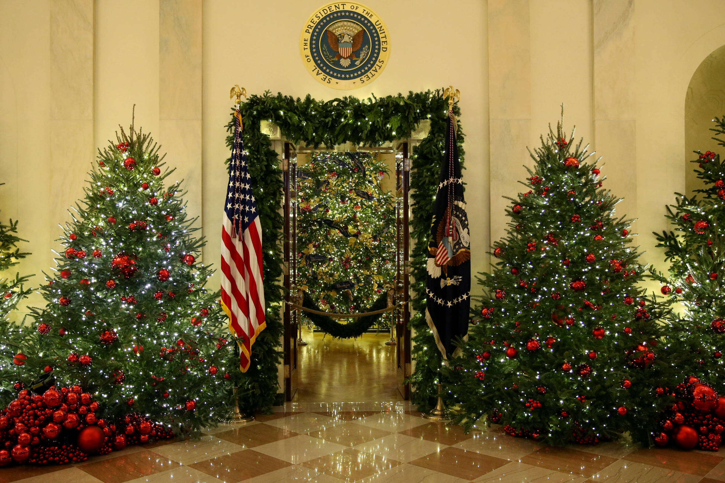 Sala de estar de natal branca e dourada com árvore de natal e