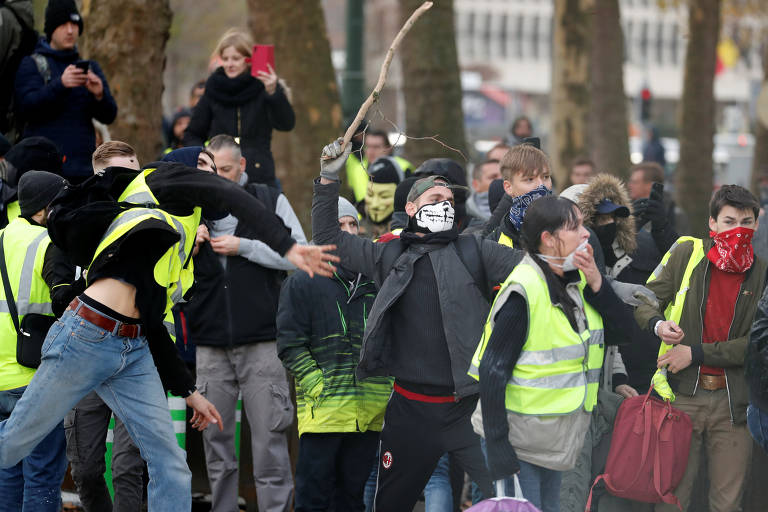Manifestantes mascarados entram em confronto com a polícia durante ato em Bruxelas, na Bélgica, contra alta do preço dos combustíveis