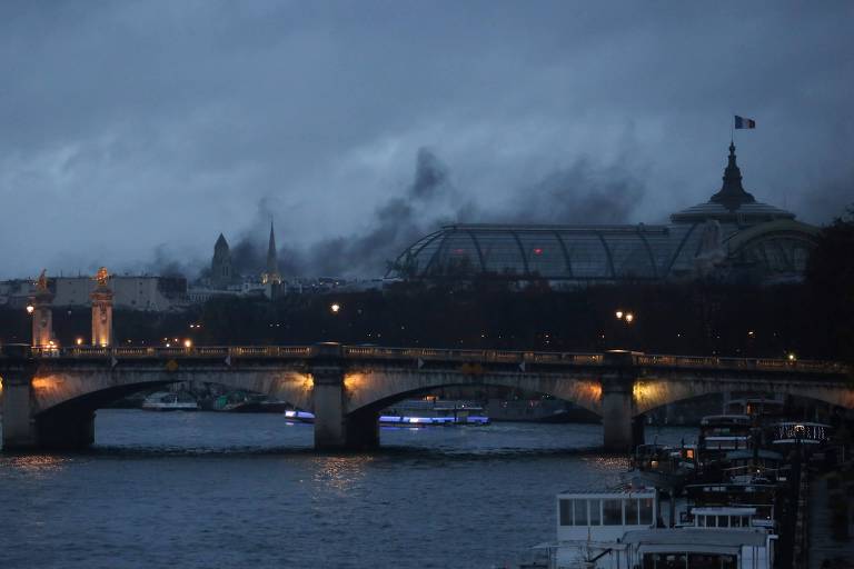 Fumaça sobe sobre o Grand Palais durante confrontos entre manifestantes dos 'coletes amarelos' e policiais neste sábado (1º) em Paris