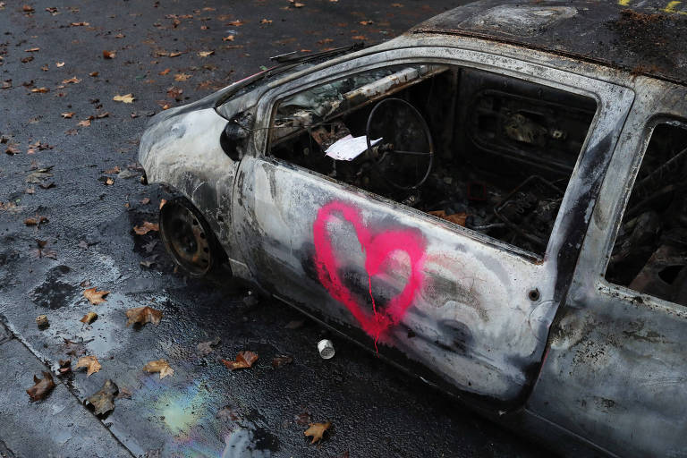 Foto de carro carbonizado perto do Arco do Triufo, um dia após as manifestações dos