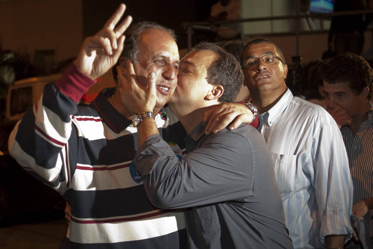 Pezão (à esq.) é beijado por Sérgio Cabral