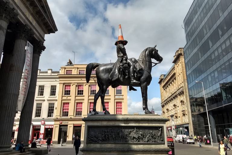 Estátua de homem montado em cavalo, com cone na cabeça 