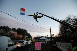 Protesters wearing yellow vests, the symbol of a French drivers' protest against higher diesel fuel prices, occupy a roundabout in Cissac-Medoc