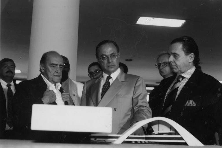 O arquiteto Oscar Niemeyer, o então prefeito Paulo Maluf e Edemar Cid Ferreira, presidente da Bienal, olham maquete durante a inauguração da 2ª Bienal Internacional de Arquitetura, em São Paulo
