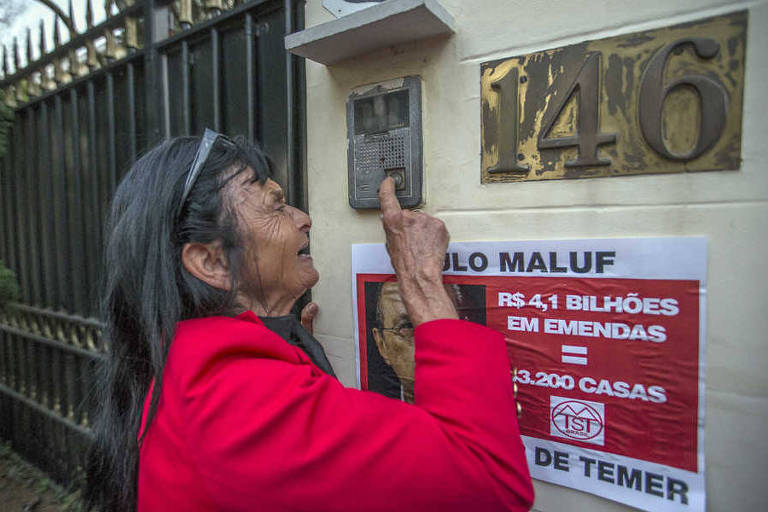 Manifestante do MTST protesta em frente à casa do deputado Paulo Maluf (PP-SP) por causa de emendas recebidas por deputados para supostamente votarem pelo arquivamento das denúncias contra o presidente Michel Temer
