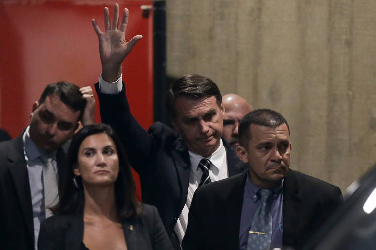 O presidente eleito, Jair Bolsonaro, acena ao deixar o CCBB, onde funciona o gabinete de transição