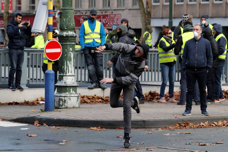 Manifestante joga objeto contra policiais em protesto em Bruxelas, na Bélgica