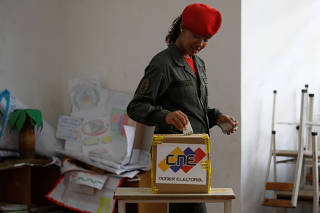 A Venezuelan soldier casts her vote at a polling station during the municipal legislators election in Caracas