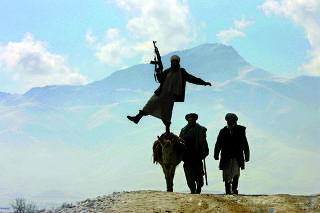 Afghan men and donkey climb up a hill on the outskirts of Kabul