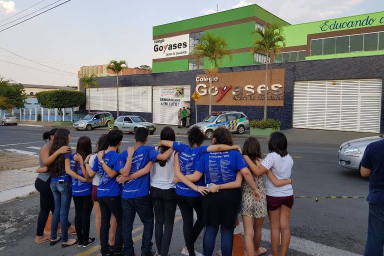 Estudantes se abraçam na porta do colégio Goyases, em Goiânia, onde estudante atirou contra colegas e matou dois adolescentes