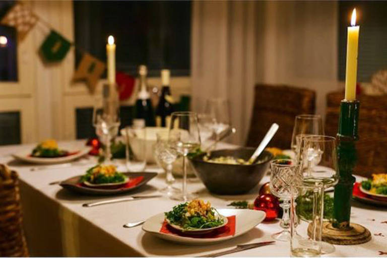 Ceia de Natal com velas, pratos, taças e travessas à mesa