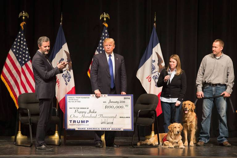 O então pré-candidato republicano Donald Trump dá um cheque da Fundação Trump para o projeto Puppy Jake no estado do Iowa, em janeiro de 2016
