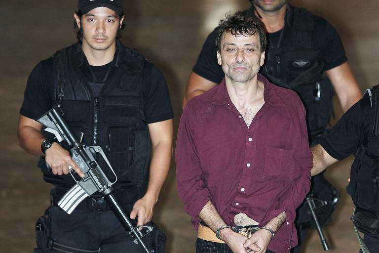 O ex-ativista italiano Cesare Battisti chega sob custódia ao aeroporto de Brasília, em março de 2007, depois de detido no Rio de Janeiro