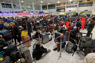 Passengers wait around in the South Terminal building at Gatwick Airport after drones flying illegally over the airfield forced the closure of the airport, in Gatwick