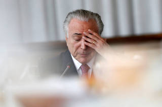 Brazil's President Michel Temer reacts during a breakfast with foreign media at Alvorada Palace in Brasilia