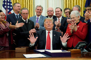 U.S. President Trump is applauded as he says he will not answer reporters questions during bill signing ceremony at White House in Washington