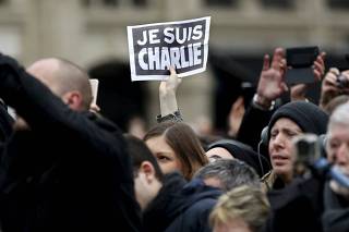 Person holds up a sign during a ceremony at Place de la Republique square to pay tribute to the victims of last year's shooting at the French satirical newspaper Charlie Hebdo, in Paris