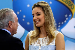 First lady Marcela Temer smiles near Brazil's President Michel Temer during a launch ceremony of the Happy Child Program at the Planalto Palace in Brasilia