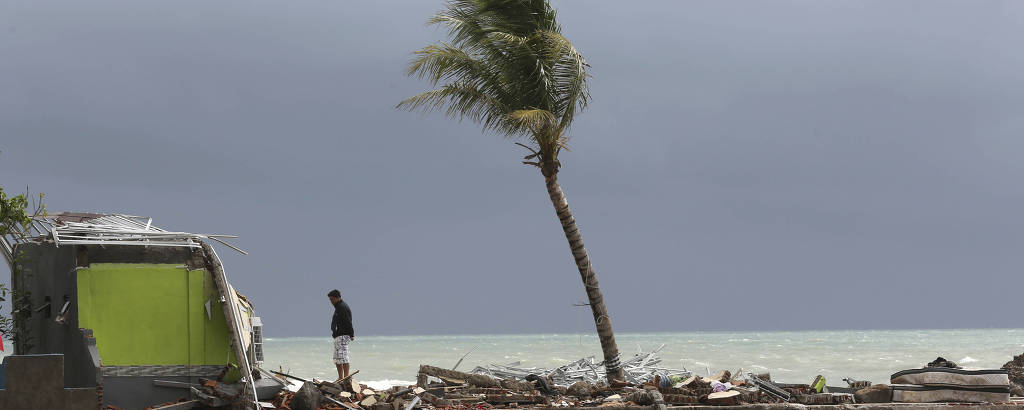 Homem observa rastro da destruiÃ§Ã£o provocada pelo tsunami na praia de Carita, na IndonÃ©sia