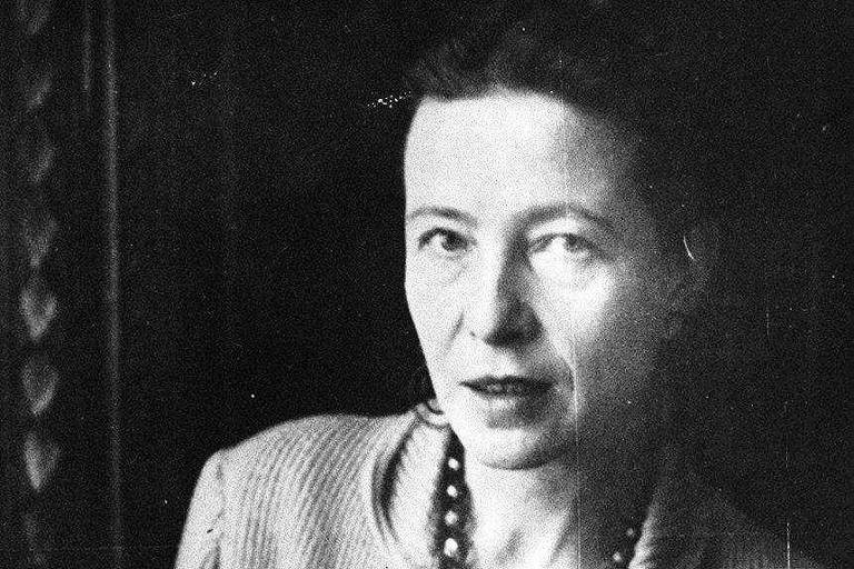 Simone de Beauvoir olhando para a câmera e com um colar