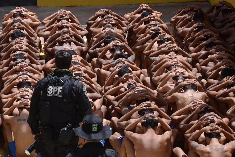 Presos do complexo penitenciário de Alcaçuz agachados, com as mãos na cabeça, durante contagem e banho de sol