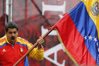 Venezuela's President Maduro waves a national flag outside Miraflores Palace in Caracas