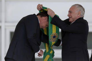 Jair Bolsonaro recebe a faixa presidencial das mãos do presidente Michel Temer